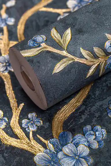 Rolled wallpaper with blue florals and gold branches on a deep teal textured background