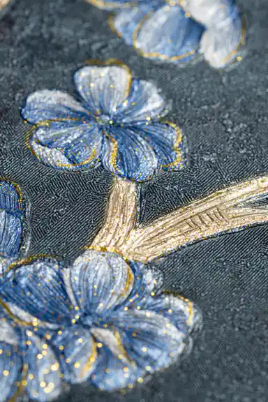 Extreme macro of blue glitter petals and gold stem texture on deep teal wallpaper surface