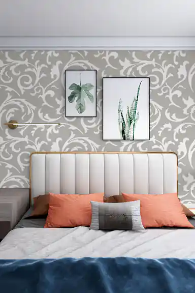 Modern bedroom with grey scrollwork wallpaper installed behind a white tufted bed with coral pillows and botanical wall art