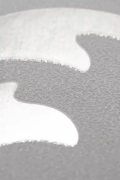 Extreme macro showing the silver glitter shimmer texture along a single curve on grey wallpaper