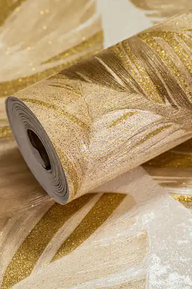 Wallpaper roll showing tropical palm leaves with gold glitter sparkle on a warm beige background