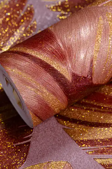Wallpaper roll with burgundy palm leaves and rich gold glitter accents on a dusty rose background