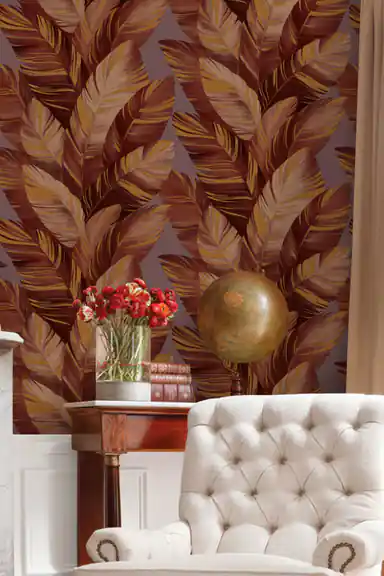 Elegant room scene with burgundy palm leaf wallpaper behind a tufted armchair, globe, and red flowers