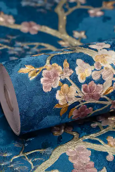 Wallpaper roll with pink cherry blossoms on golden branches against a rich blue textured background