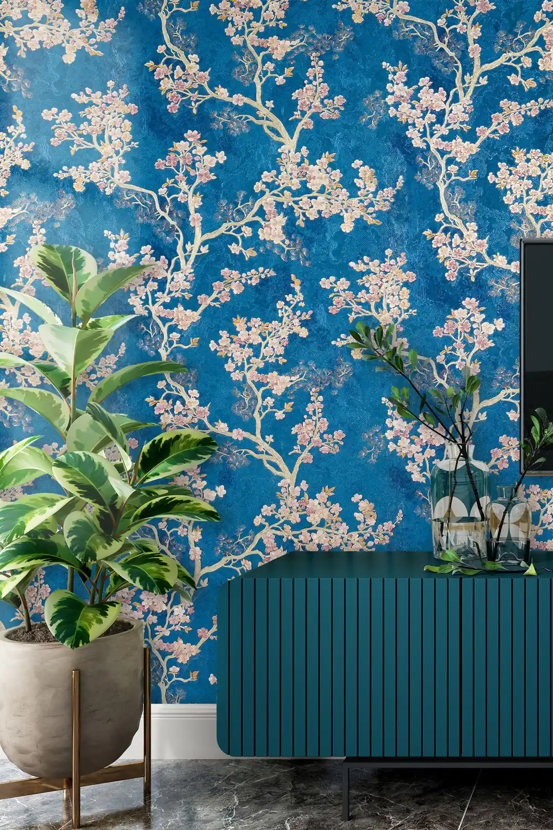 Living room with blue cherry blossom wallpaper installed behind a teal ribbed sideboard and potted plants