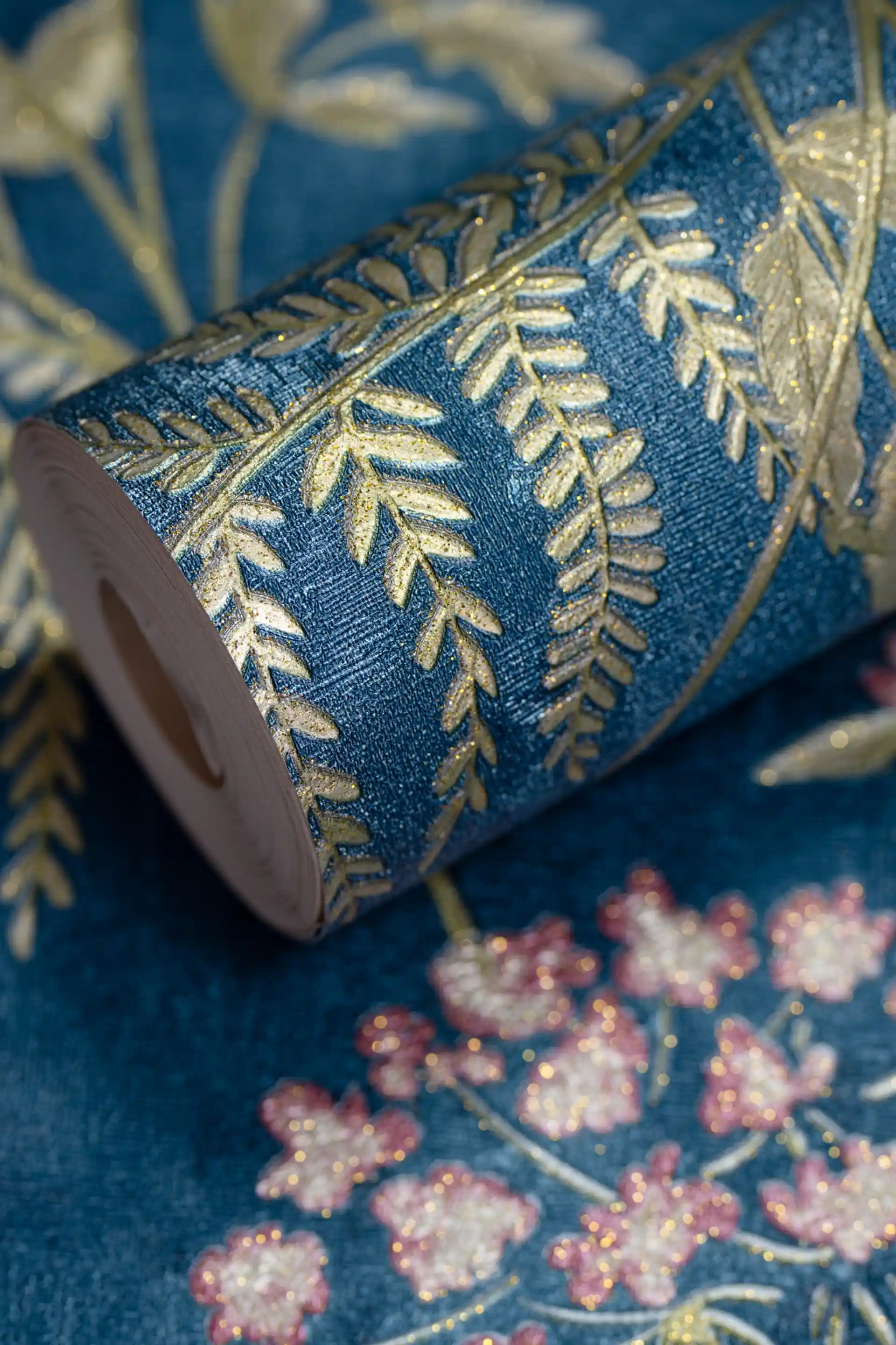 Wallpaper roll with royal blue background featuring pink hydrangea flowers and golden fern leaves