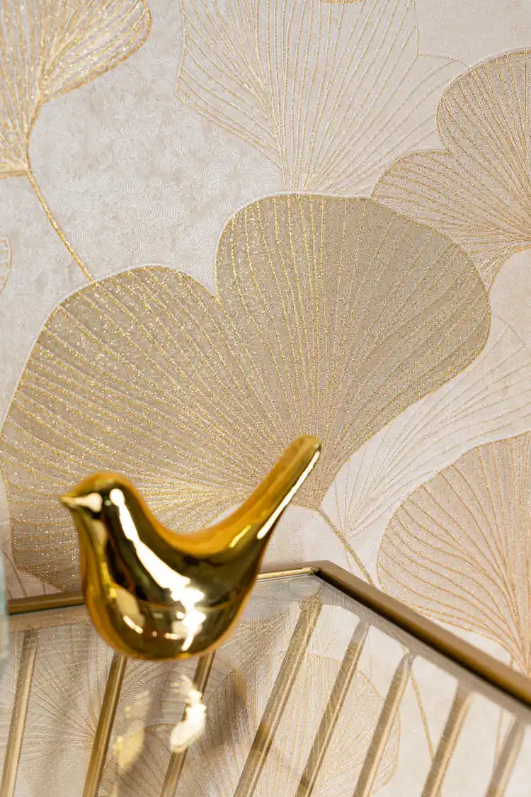Close-up of glittery ginkgo leaf wallpaper showing gold-lined fan-shaped leaves with a decorative gold bird accent