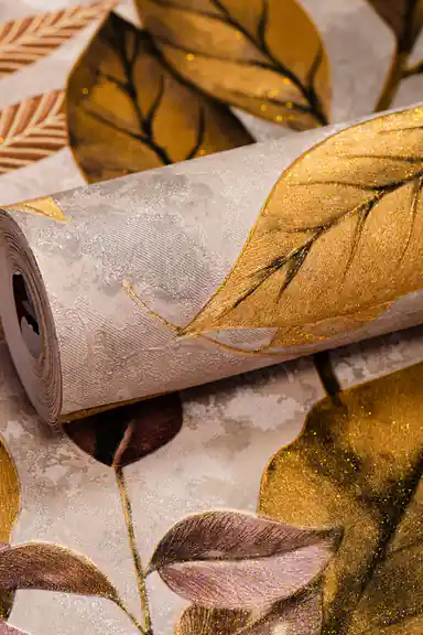 Rolled wallpaper displaying warm golden autumn leaves with shimmer on a grey marbled background