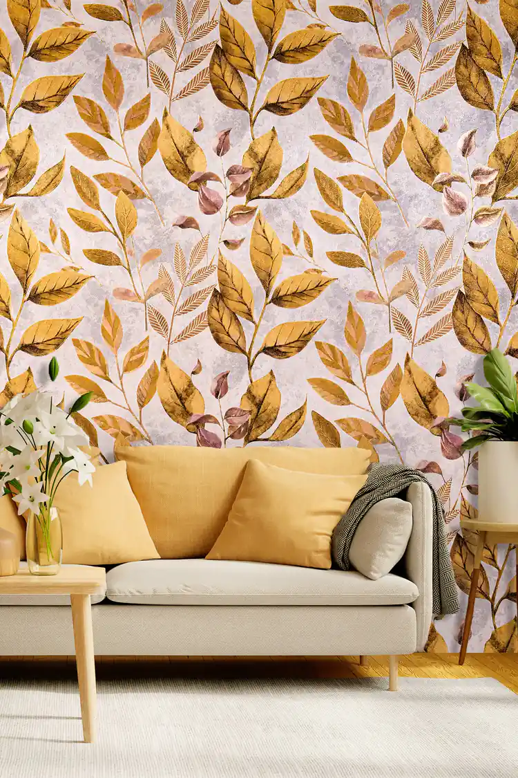 Golden autumn leaves botanical wallpaper in a living room with a mustard sofa and white lily arrangement