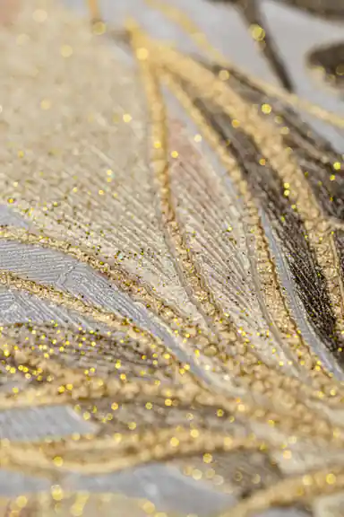 Extreme close-up of copper and gold glitter details on tropical leaf and orchid wallpaper texture