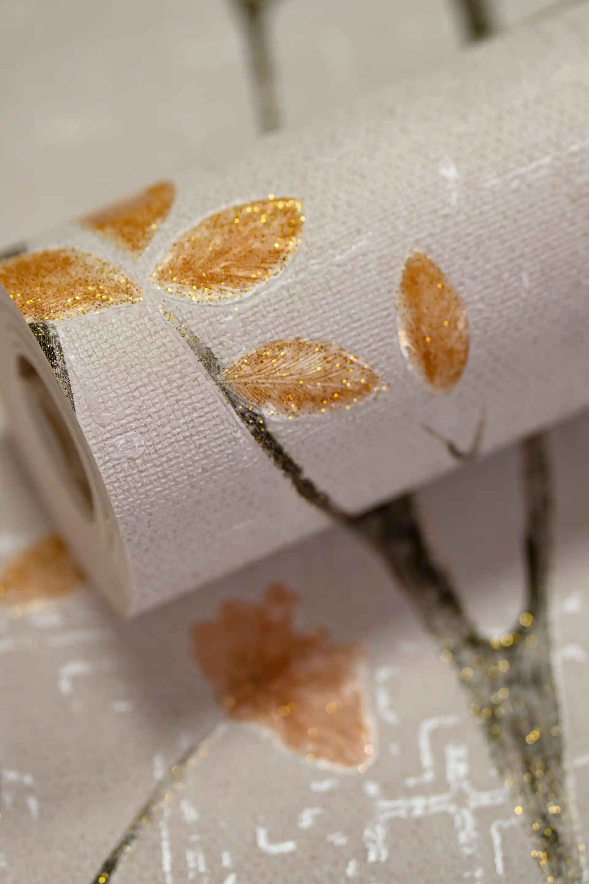 Rolled white wallpaper with black birch branches and small orange glitter leaves on a light textured base