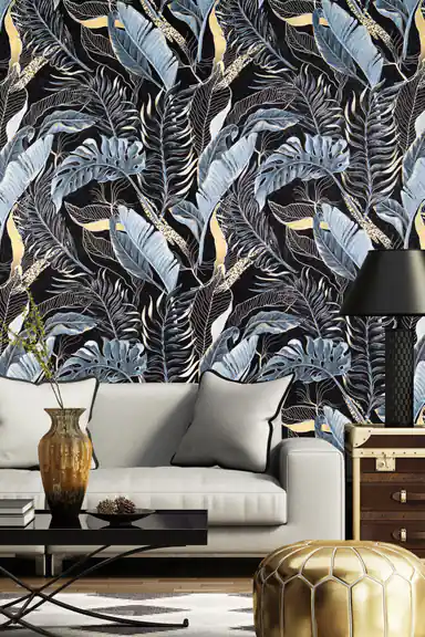 Dark tropical jungle wallpaper in a luxurious living room with a grey sofa and gold leather pouf