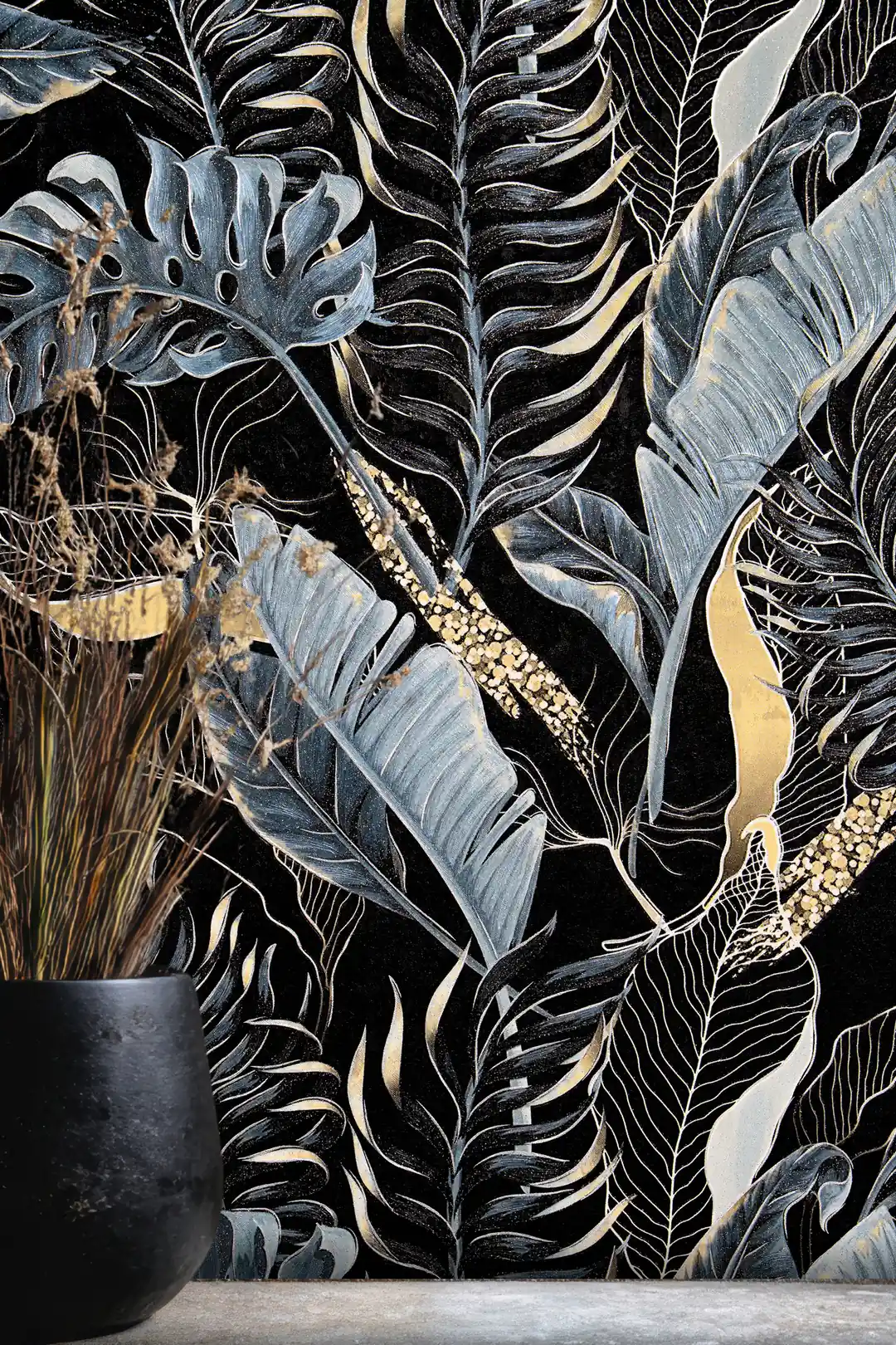 Close-up of midnight blue banana leaves and monstera fronds with gold accents on black wallpaper