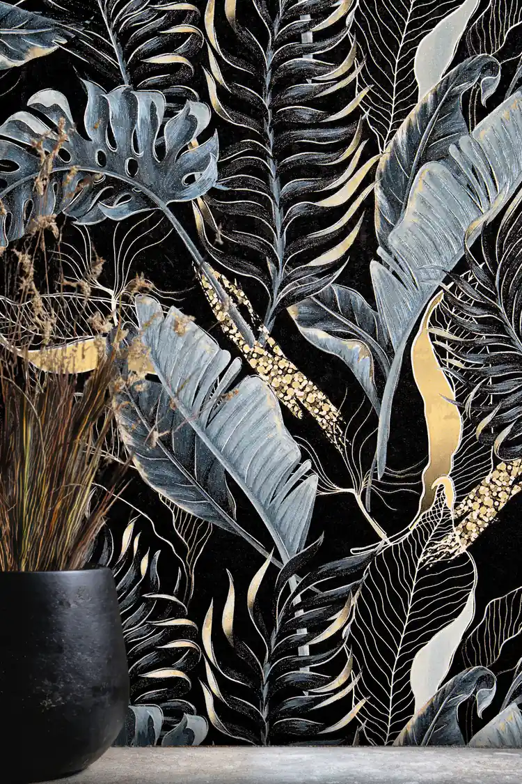 Close-up of midnight blue banana leaves and monstera fronds with gold accents on black wallpaper
