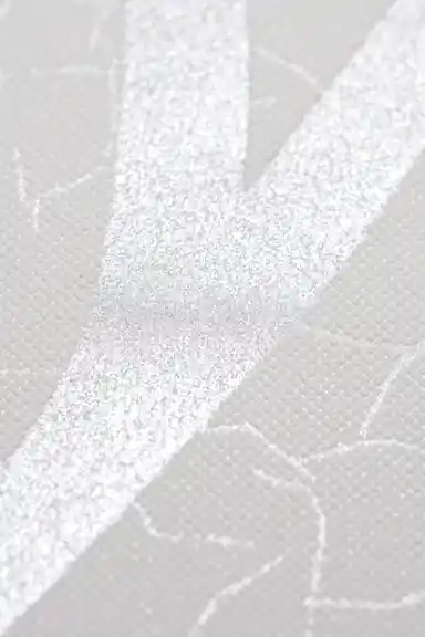 Extreme macro of silver glitter swirl texture on white base showing the shimmering surface detail