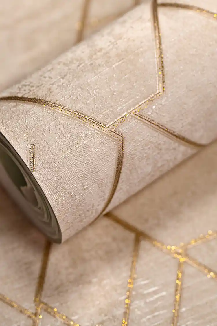 Rolled beige wallpaper with geometric hexagonal pattern outlined in gold glitter lines on a textured base