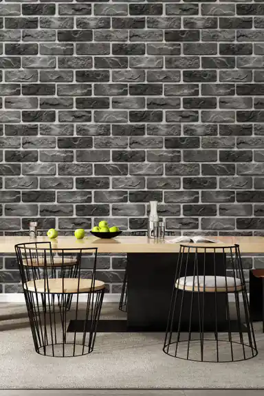 Charcoal grey stone brick wallpaper installed in a dining room with a modern table and wire-frame chairs