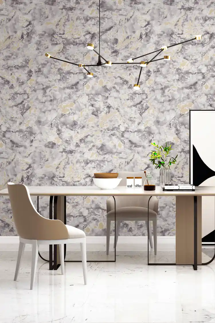 Grey marble wallpaper with gold accents in a modern dining room with chandelier and beige upholstered chairs