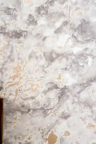 Detailed view of grey and white marble wallpaper texture with gold foil veining and patches