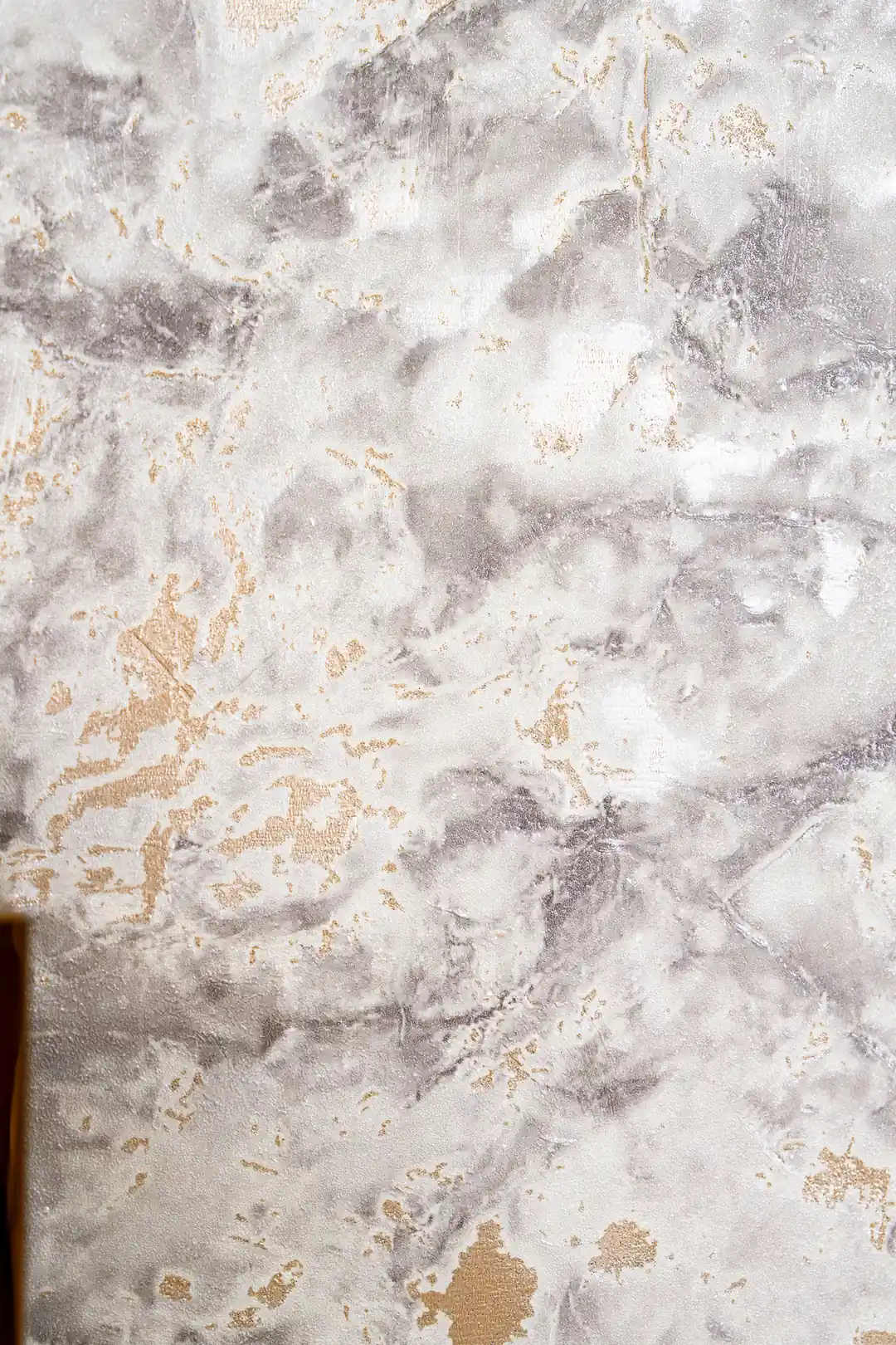 Detailed view of grey and white marble wallpaper texture with gold foil veining and patches