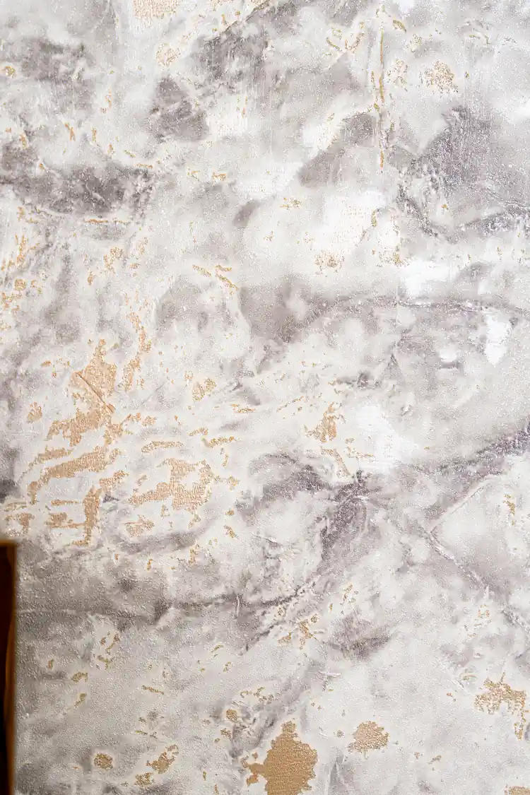 Detailed view of grey and white marble wallpaper texture with gold foil veining and patches