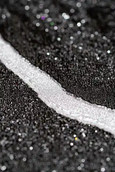 Extreme macro of silver line detail on black glitter wallpaper showing sparkling particle texture