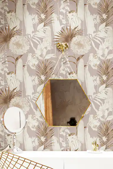 Rose gold floral wallpaper in a vanity area with a hexagonal gold mirror and botanical palm frond pattern
