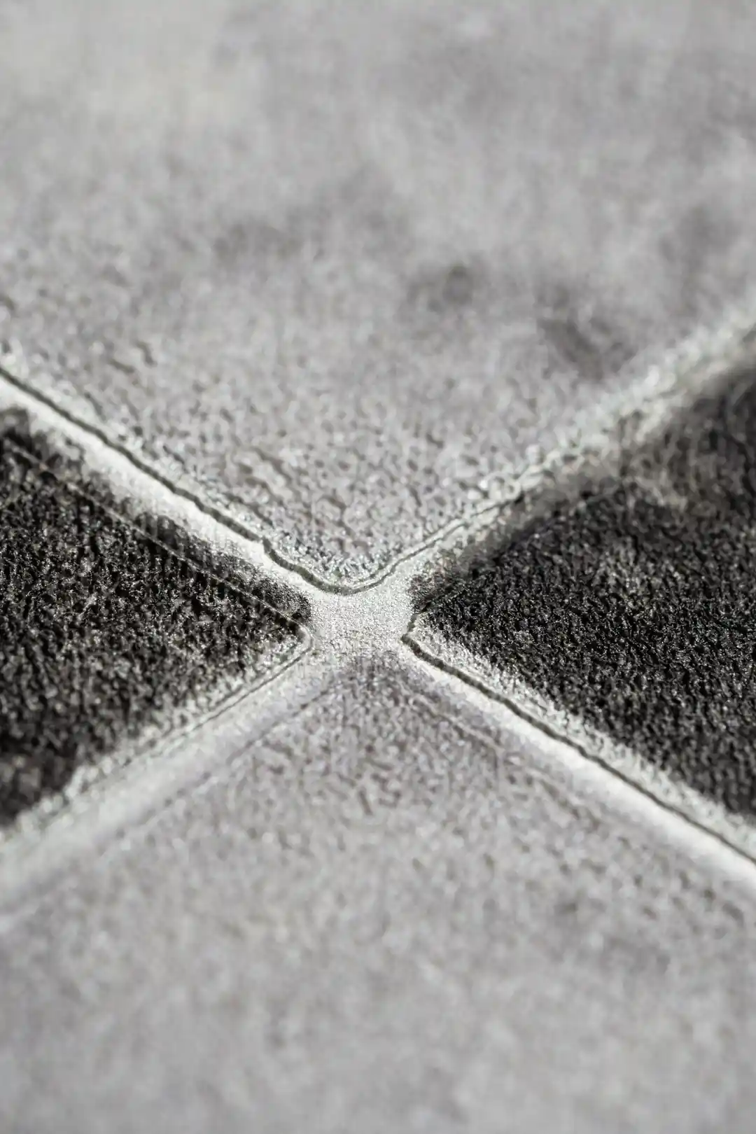 Extreme close-up of marble checker wallpaper showing embossed texture at the diamond tile intersection