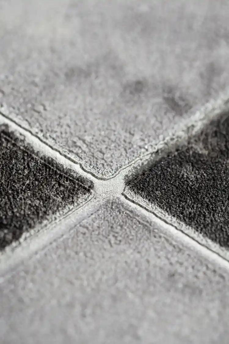 Extreme close-up of marble checker wallpaper showing embossed texture at the diamond tile intersection