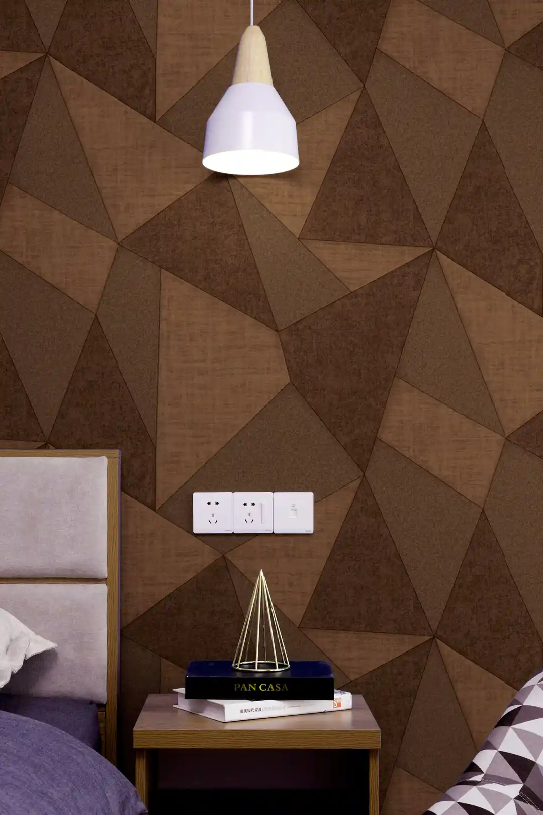 Brown 3D triangle wallpaper installed in a modern bedroom with pendant light and bedside table