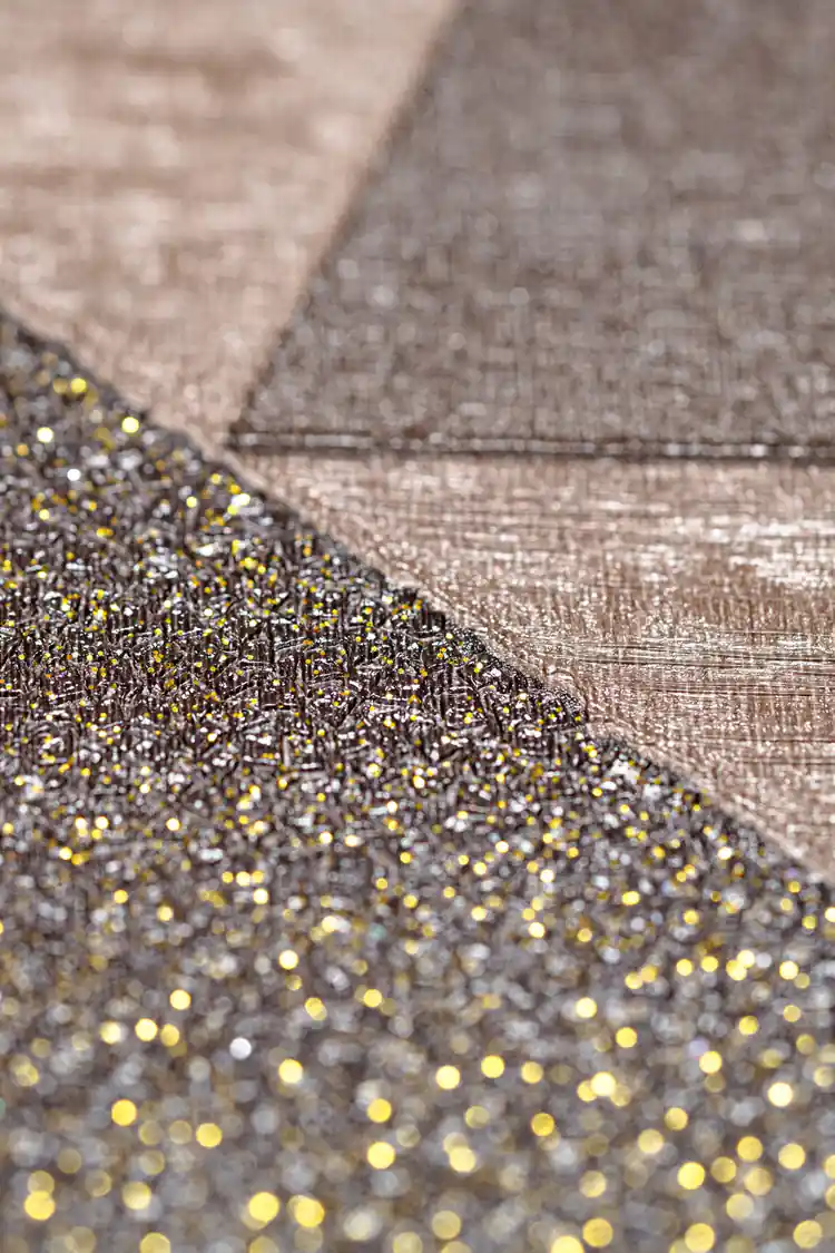 Extreme close-up of sparkly brown geometric triangle wallpaper showing glitter texture detail