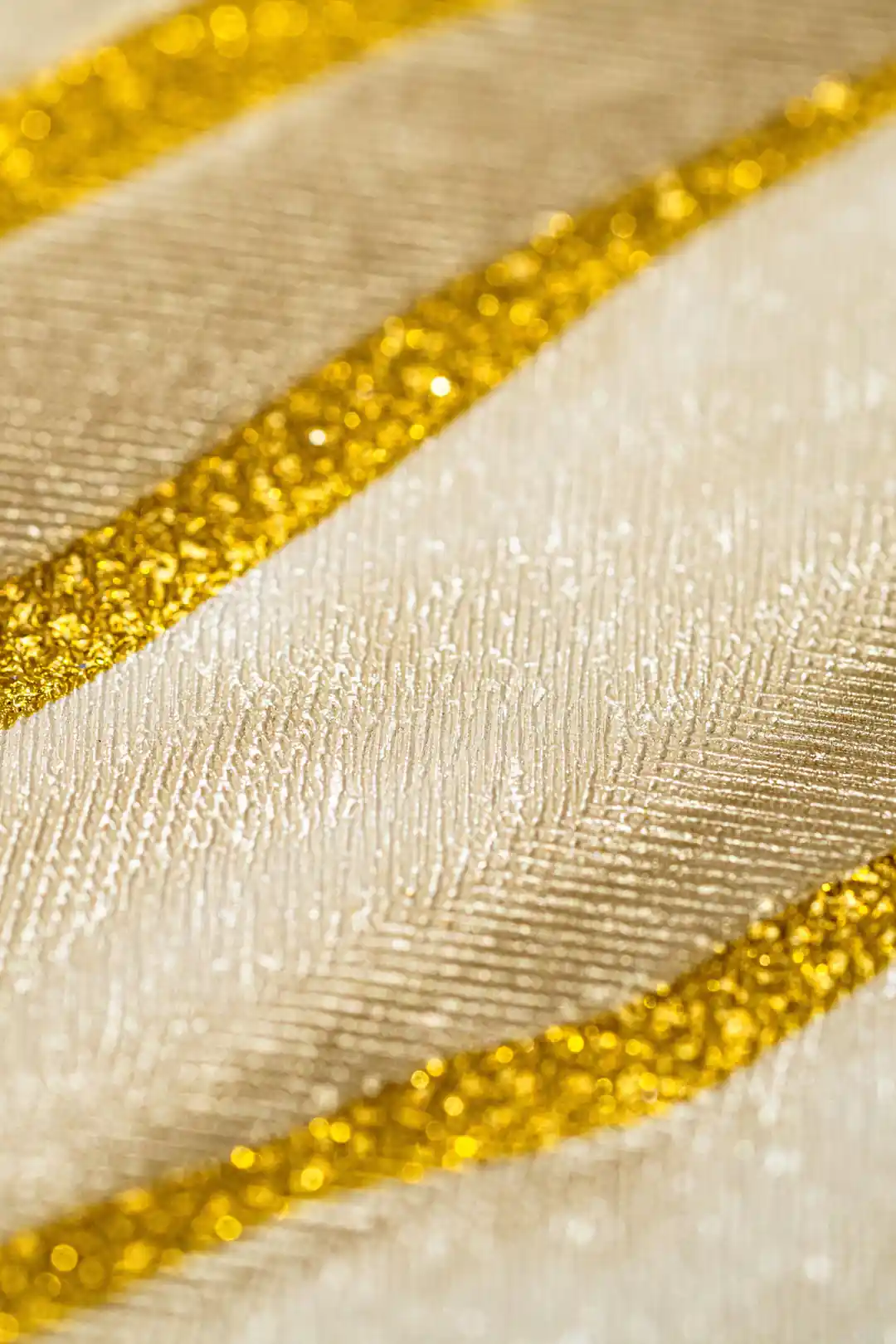Extreme close-up of cream marble wallpaper showing sparkling gold line texture detail