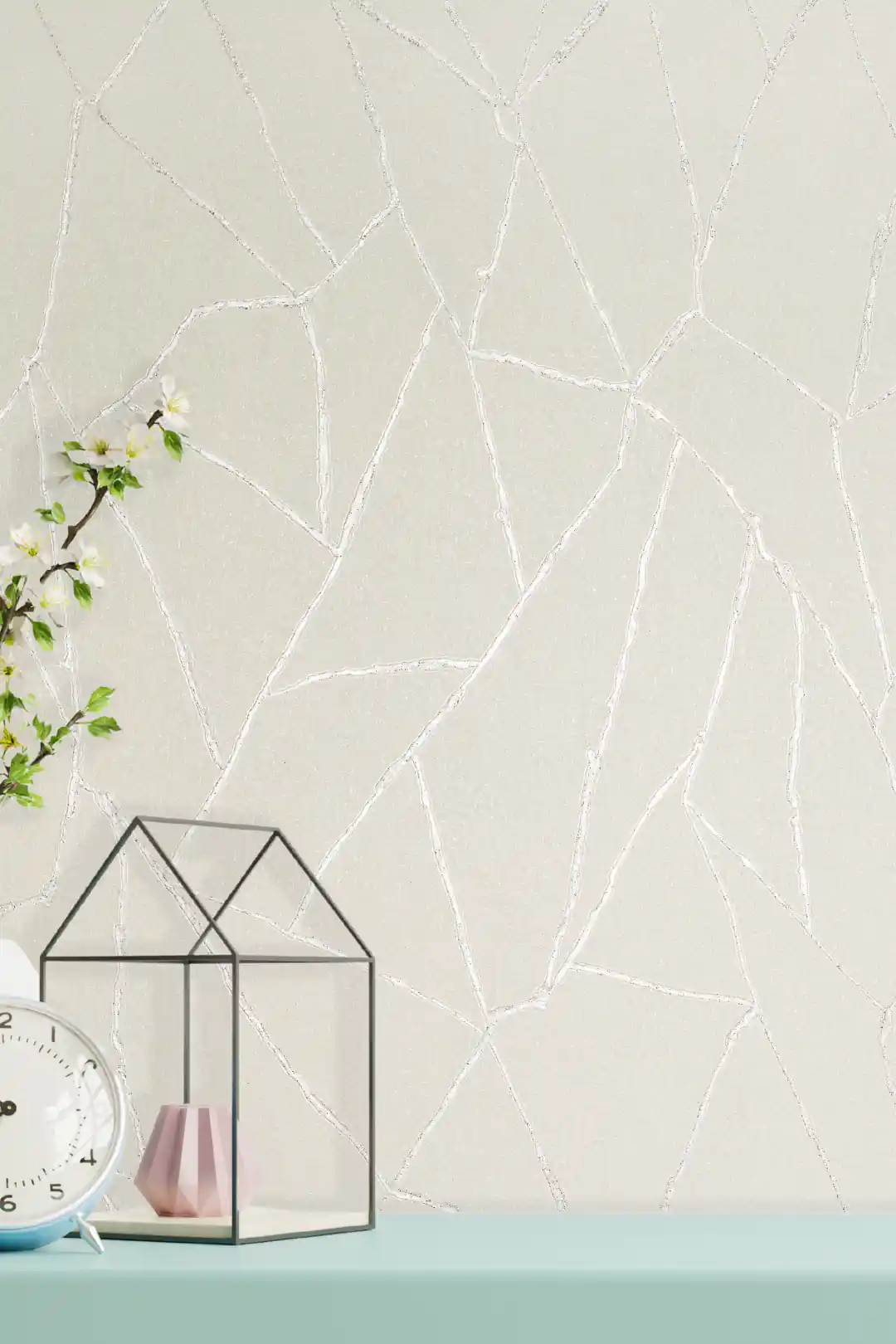 Off-white textured wallpaper with shimmering silver abstract vein lines displayed on a styled shelf