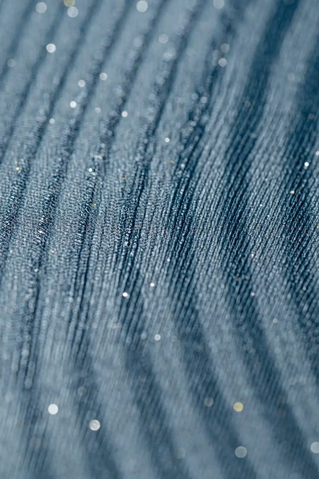 Extreme close-up of teal wave wallpaper showing fine ridged texture with sparkle detail