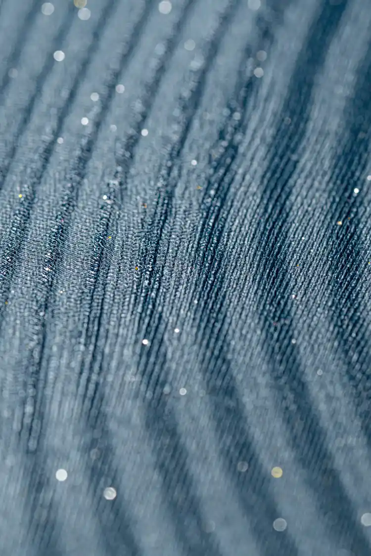 Extreme close-up of teal wave wallpaper showing fine ridged texture with sparkle detail