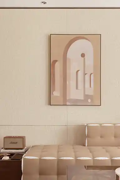 Cream grasscloth wallpaper in a bedroom setting with framed architectural art print and cream tufted daybed