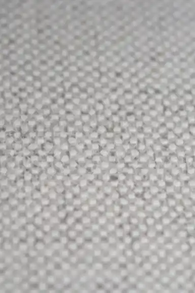 Extreme macro of grey grasscloth wallpaper showing fine woven dot texture pattern detail