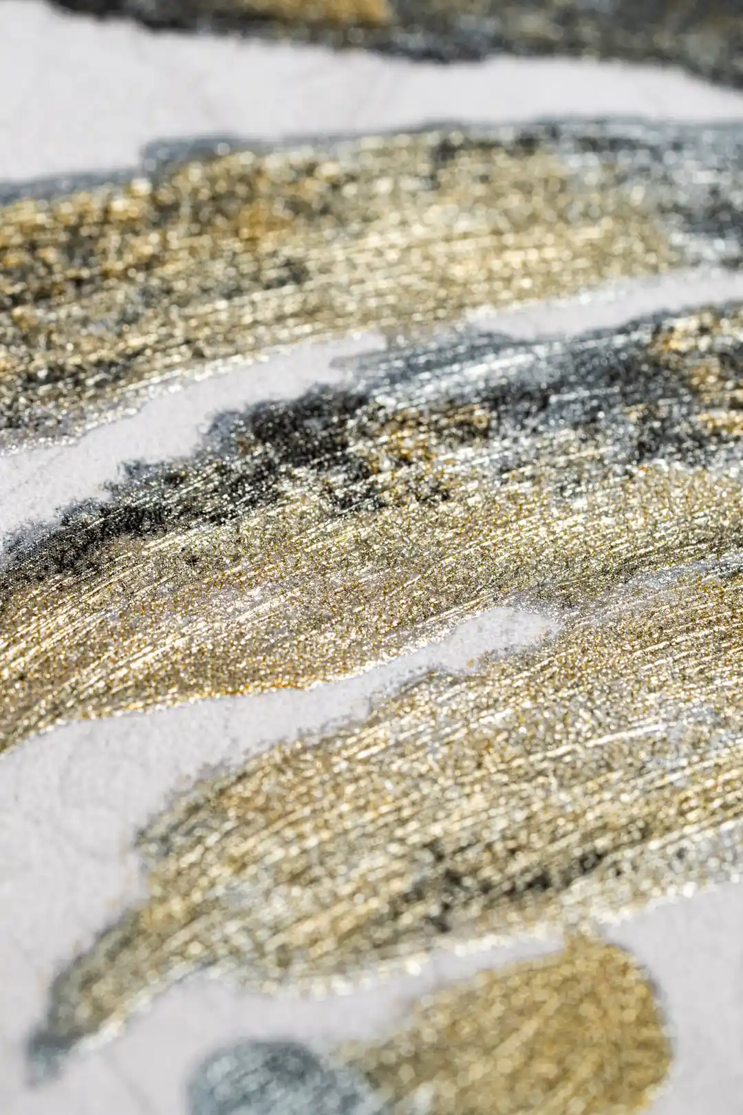 Extreme macro of fern leaf wallpaper showing gold and charcoal glitter texture on grey surface