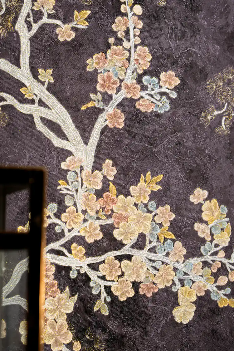 Close-up of midnight cherry blossom wallpaper with colorful embossed flowers on dark purple base