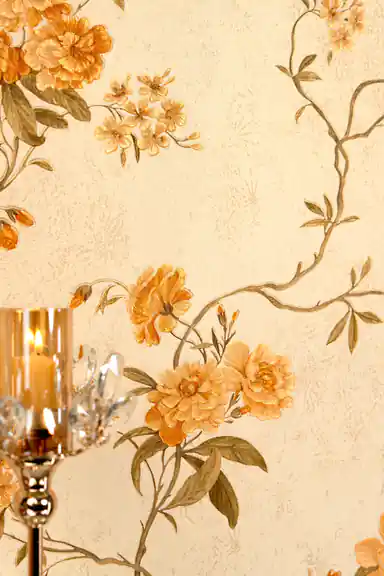 Close-up of orange peony flowers and curving vine branches on cream wallpaper with candlelight