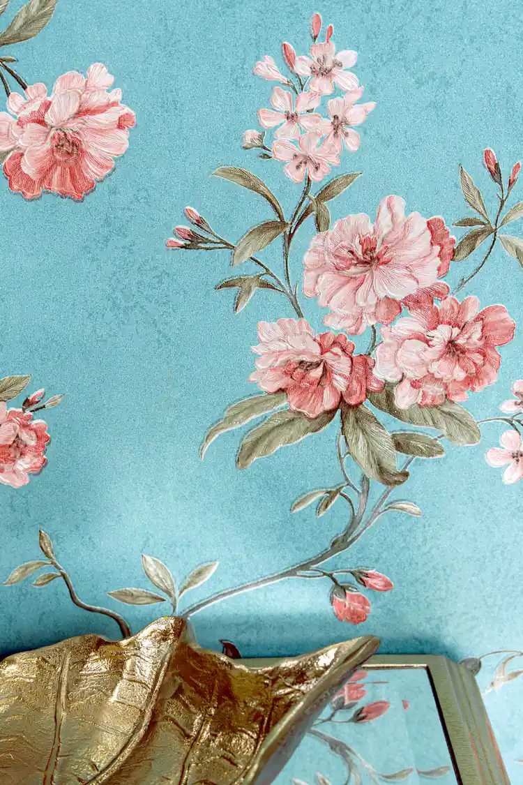 Detailed view of pink peony bloom clusters on teal blue wallpaper with gold decorative accent