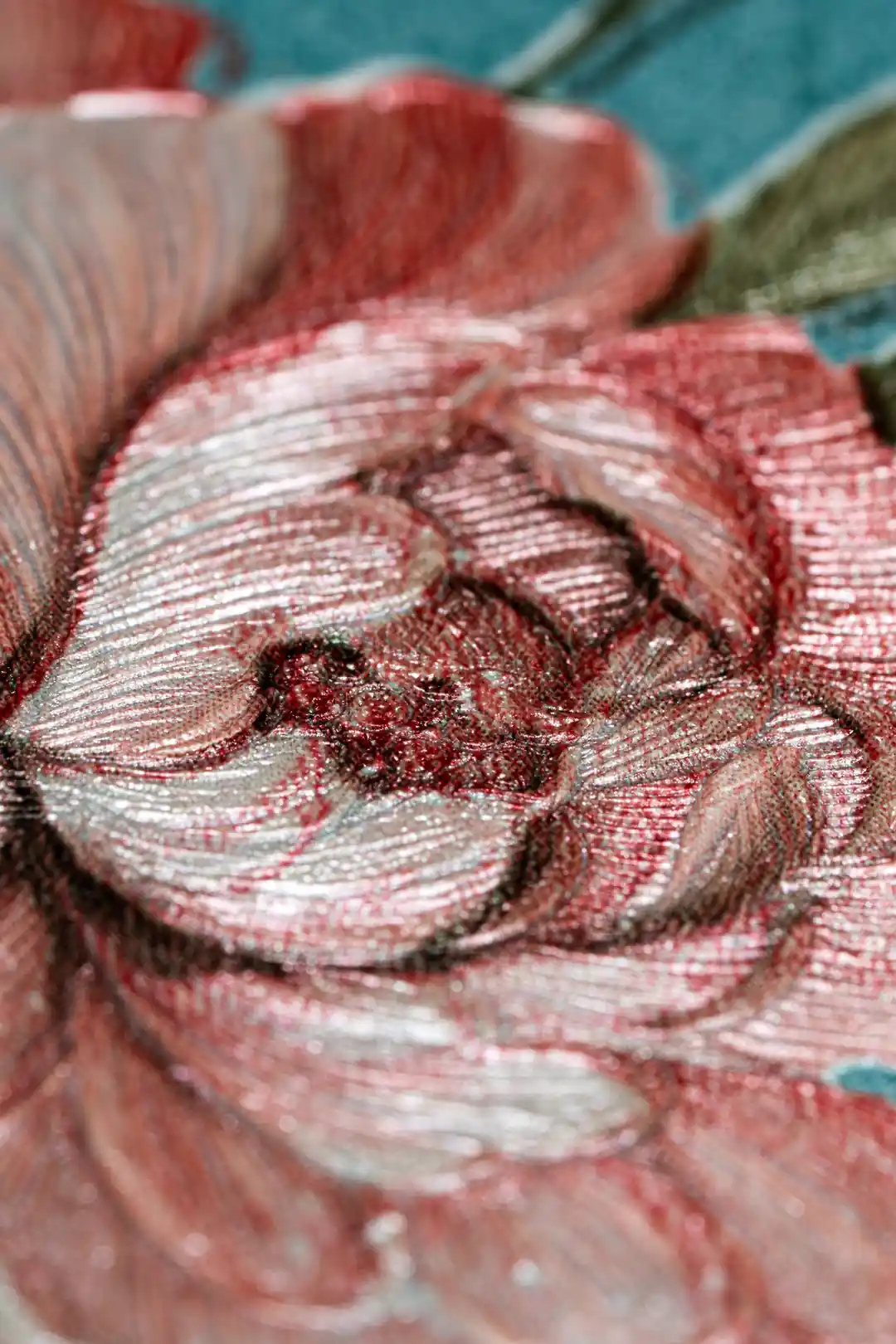 Extreme close-up macro of embossed pink peony petals showing fine texture on teal blue base