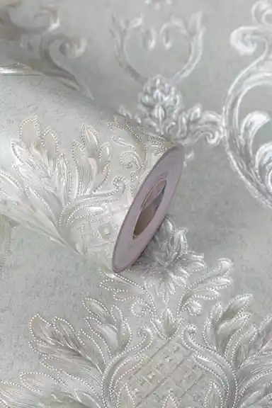 Mint green damask wallpaper roll with embossed shimmer scrollwork and floral medallions