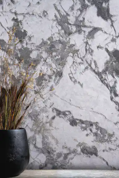 Close-up of grey and white marble veining wallpaper with black vase and dried branches
