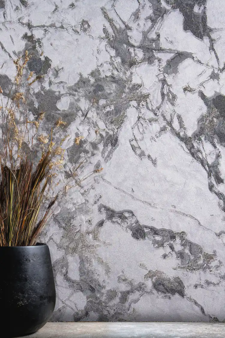 Close-up of grey and white marble veining wallpaper with black vase and dried branches