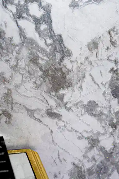 Detailed view of grey marble wallpaper surface showing glitter-flecked veining pattern
