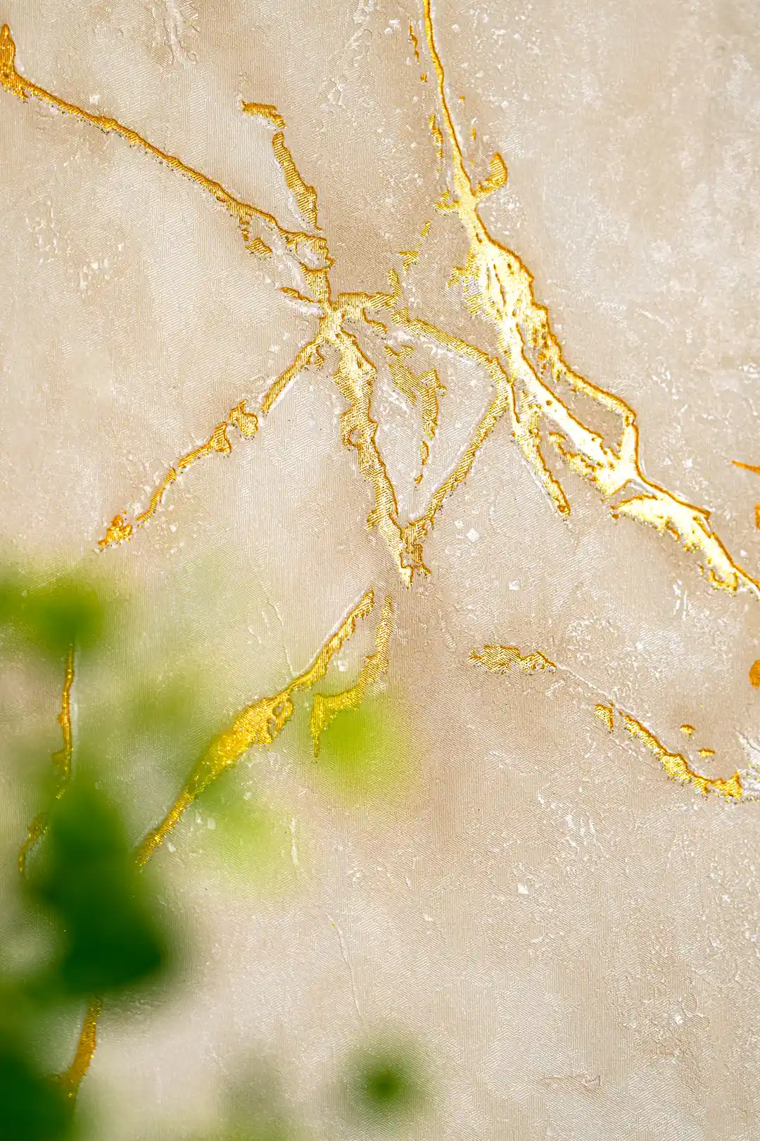 Detailed view of beige marble wallpaper with golden shimmer veins and soft texture
