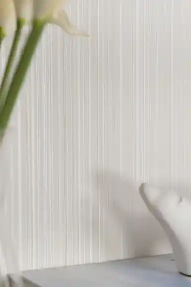 Detailed view of vertical white stripe wallpaper surface with light reflecting off silk texture