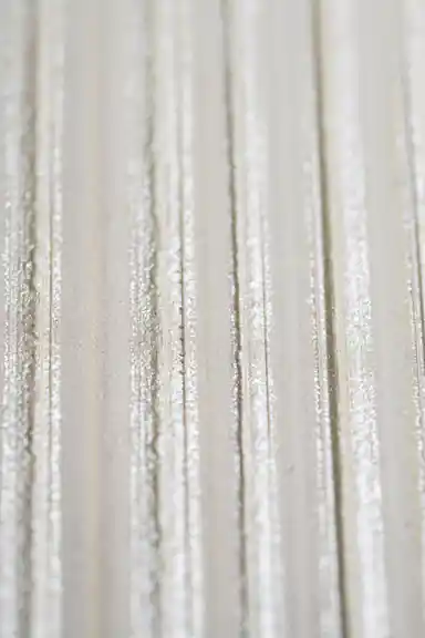 Extreme close-up of shimmer texture detail on white silk stripe wallpaper surface