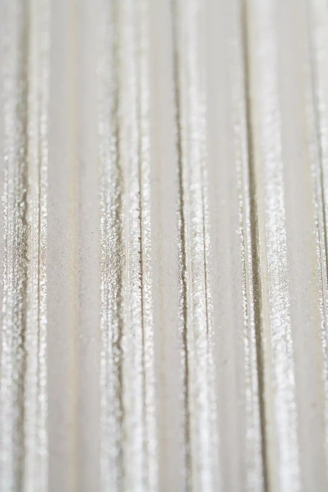 Extreme close-up of shimmer texture detail on white silk stripe wallpaper surface